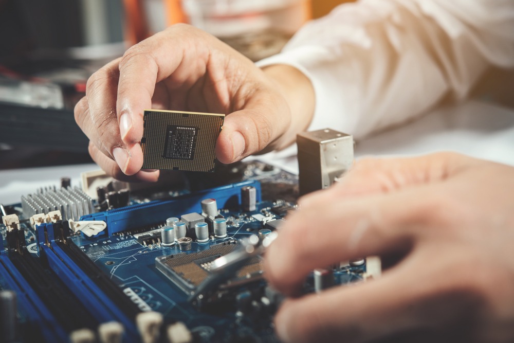 Motherboard and a hand holding a CPU